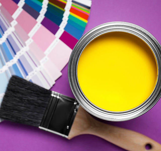 Can with yellow paint, color palette and brush on purple background, flat lay